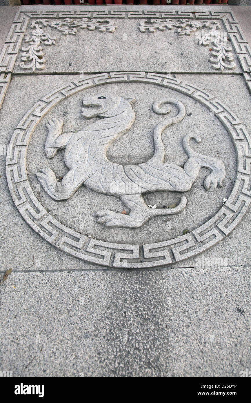 Si tratta di una foto di un bassorilievo o a basso rilievo di un dragone cinese in un cerchio su una pietra piatta. Si tratta di un simbolo. Foto Stock