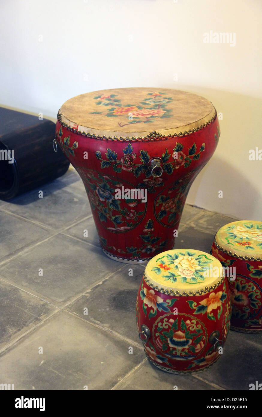 Si tratta di una foto di un tamburo di tavolo con due tamburi siede. Ha uno stile Cinese. Lo stand su pietra piastrelle stile. Colore rosso con fiore Foto Stock