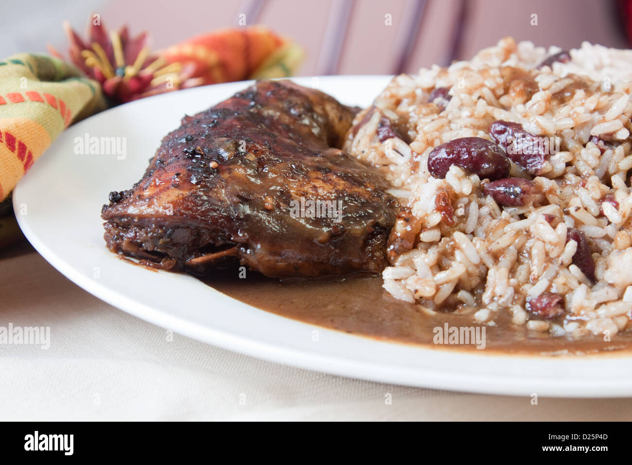 Lo stile caraibico pollo jerk servito con riso mescolato con fagioli rossi. Messa a fuoco poco profondi sul pollo. Foto Stock