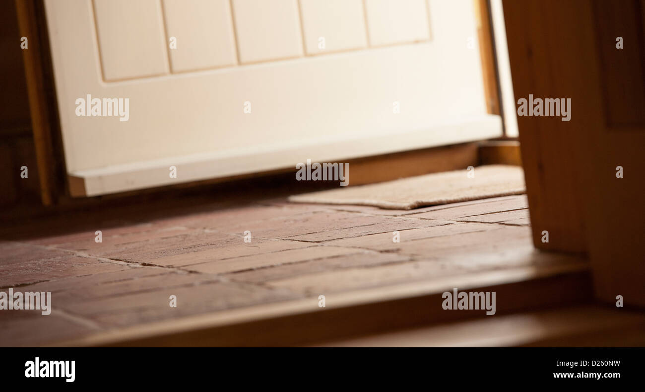 Apertura della porta in un piastrellate hall di entrata in una nuova Barn convertito in Inghilterra rurale. Foto Stock