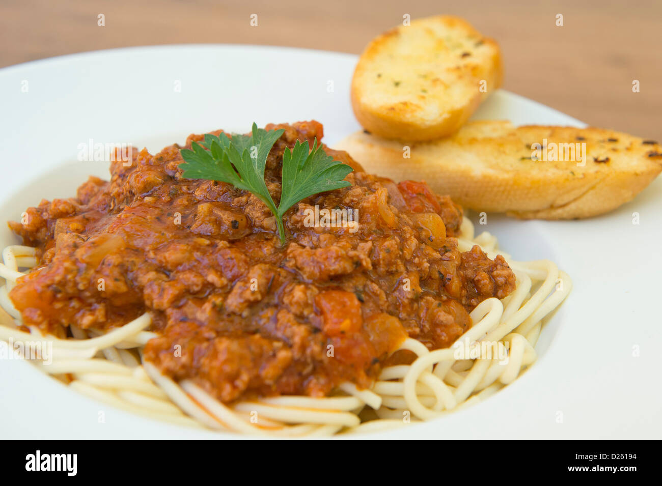 Gustosa cercando spaghetti bolognese servita con pane all'aglio. Foto Stock