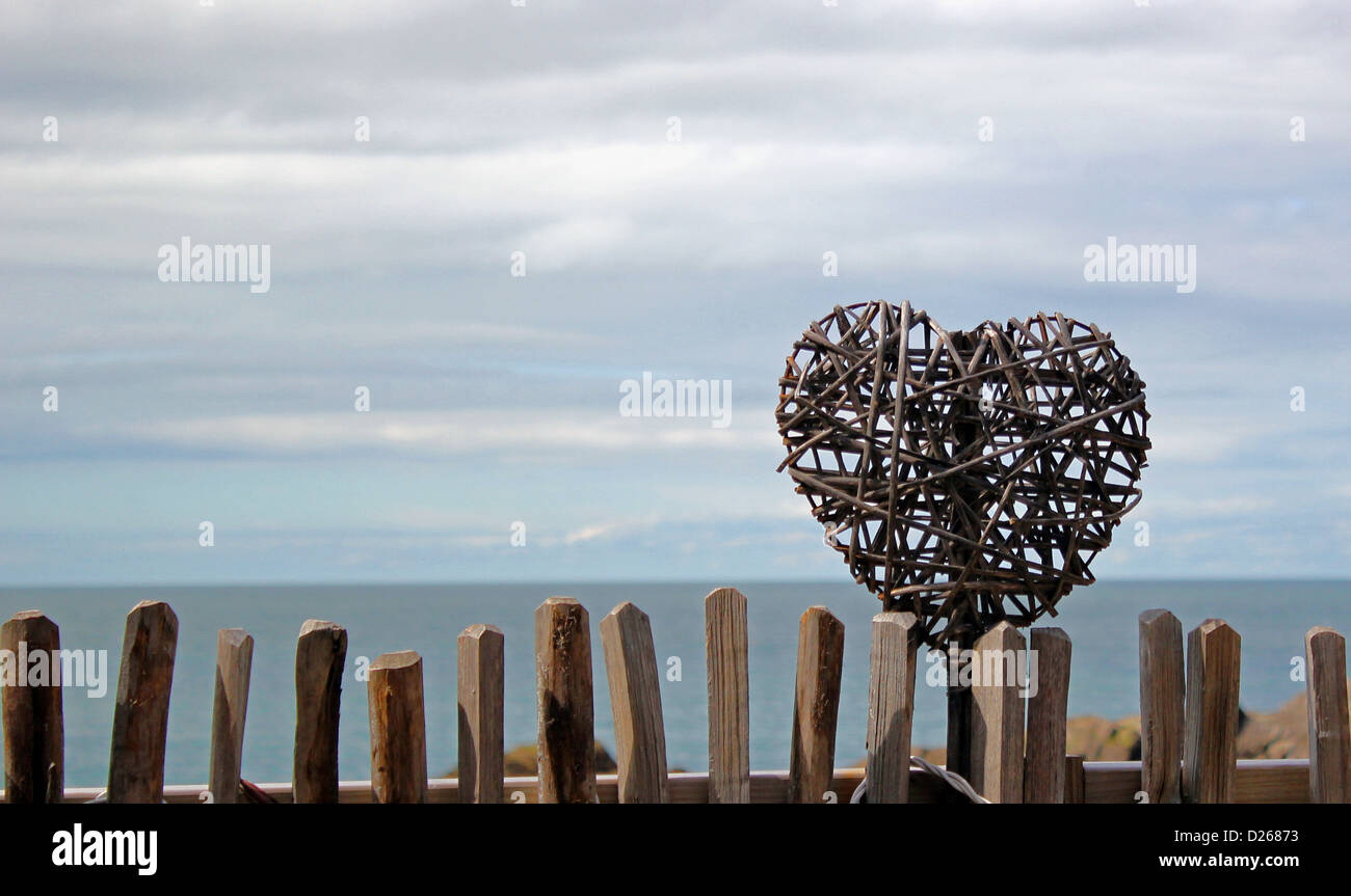 Cuore motivo sulla recinzione di legno contro uno sfondo di mare Foto Stock