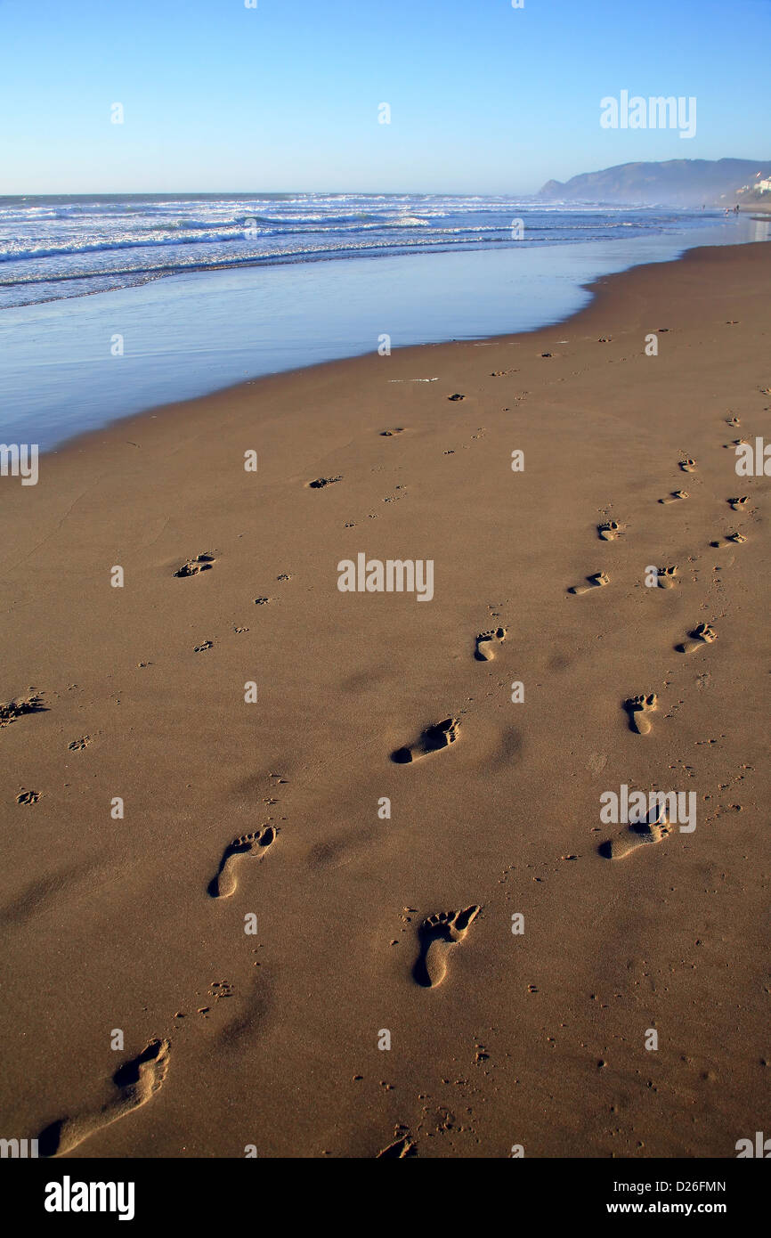 Orme nella sabbia sulla spiaggia dell'oceano Foto Stock