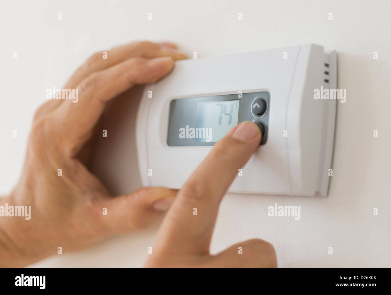 Stati Uniti d'America, New Jersey, Jersey City, mano modificando le impostazioni sul termostato dell'aria condizionata Foto Stock
