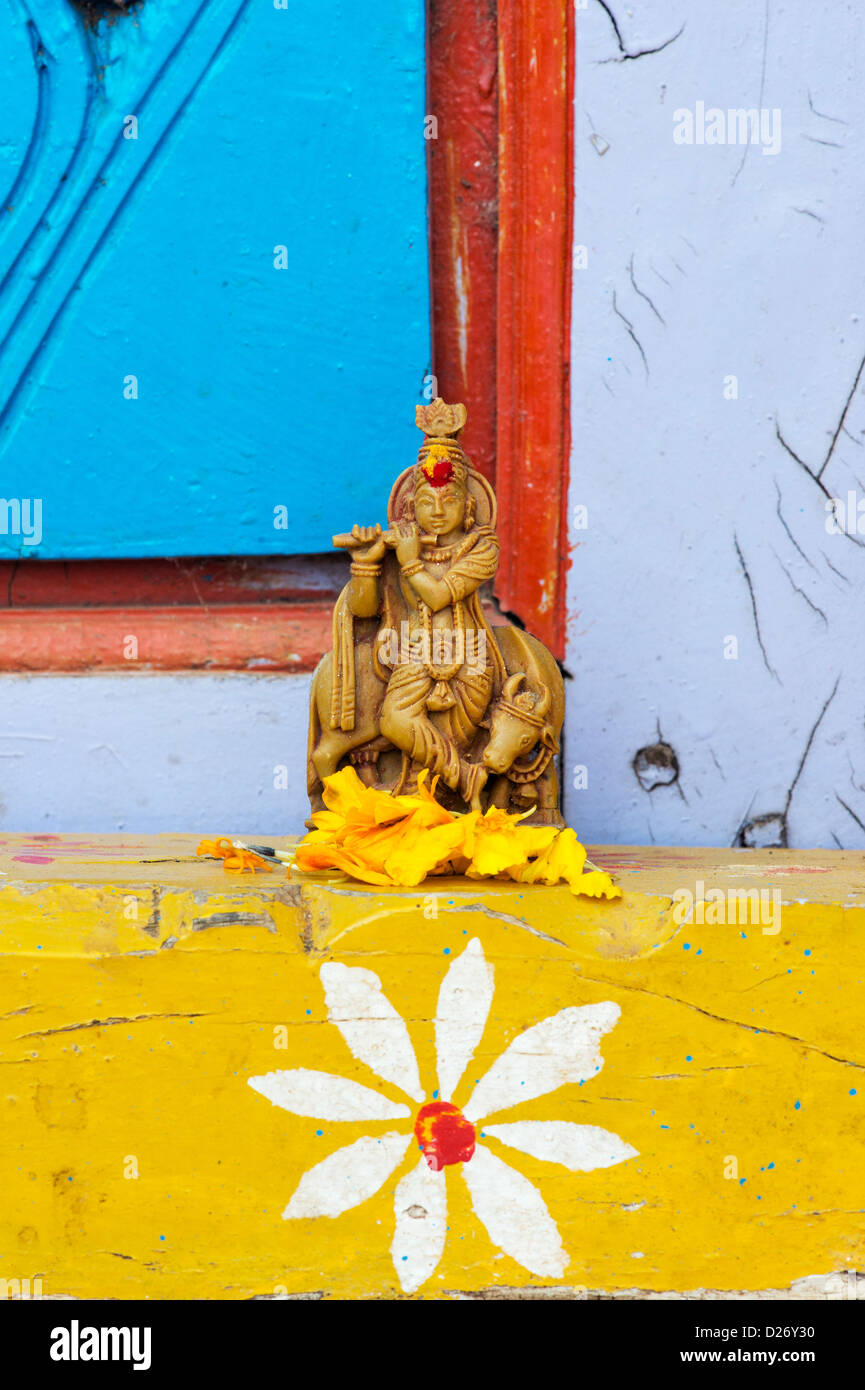 Krishna statua e petali di fiori al di fuori del tempio del villaggio porta. India Foto Stock