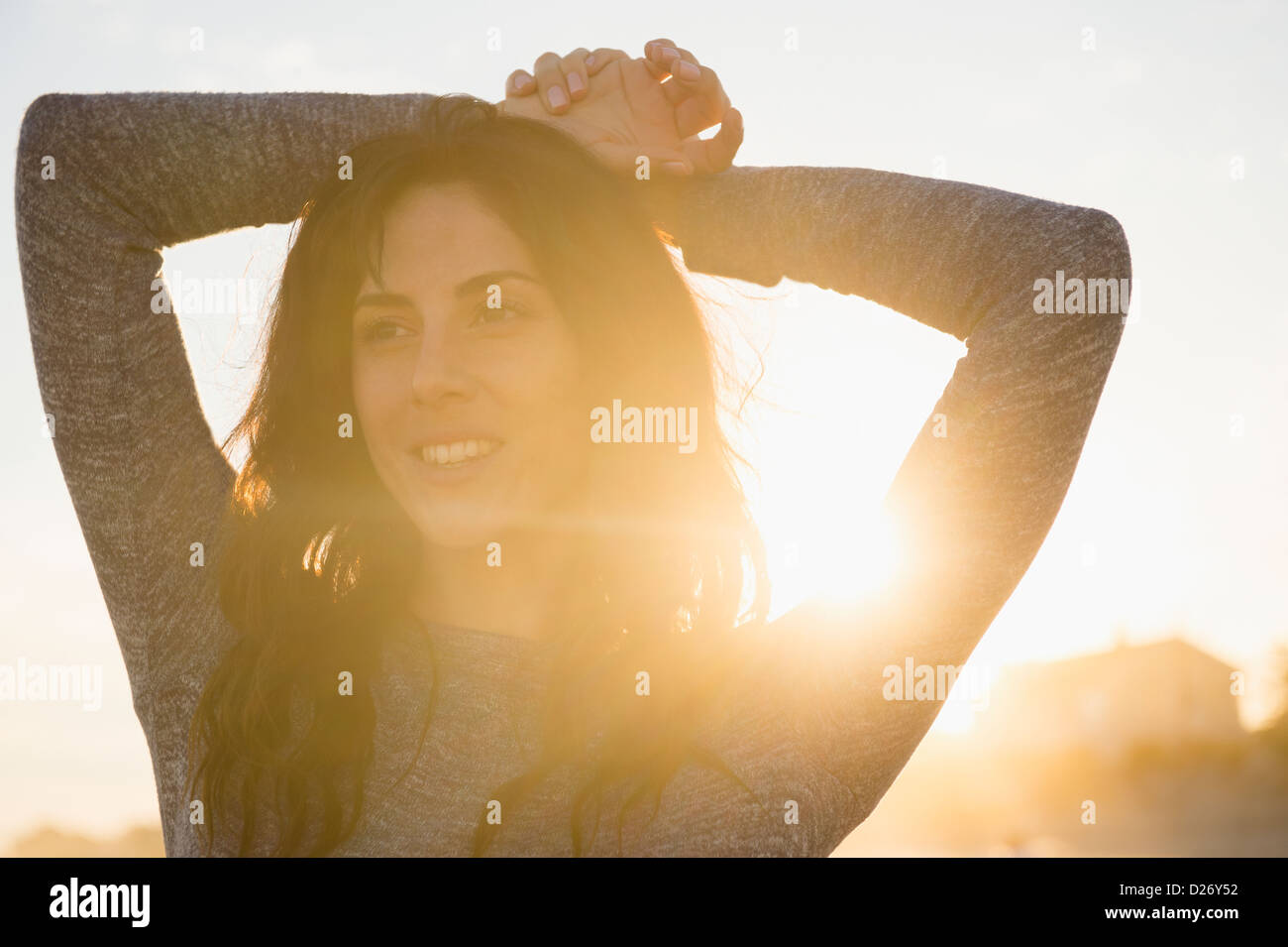 Stati Uniti d'America, nello Stato di New York, Rockaway Beach, donna sorridente al tramonto Foto Stock