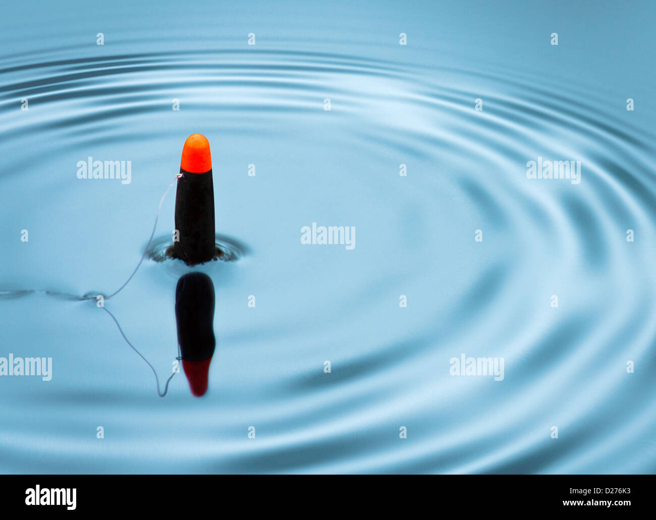 Pesca bobs galleggiante in alto e in basso la creazione di increspature per segnalare un morso Foto Stock