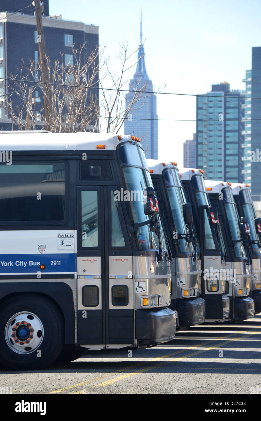 Gli autobus parcheggiati in Long Island City Queens, a New York con l'Empire State building in background. Foto Stock