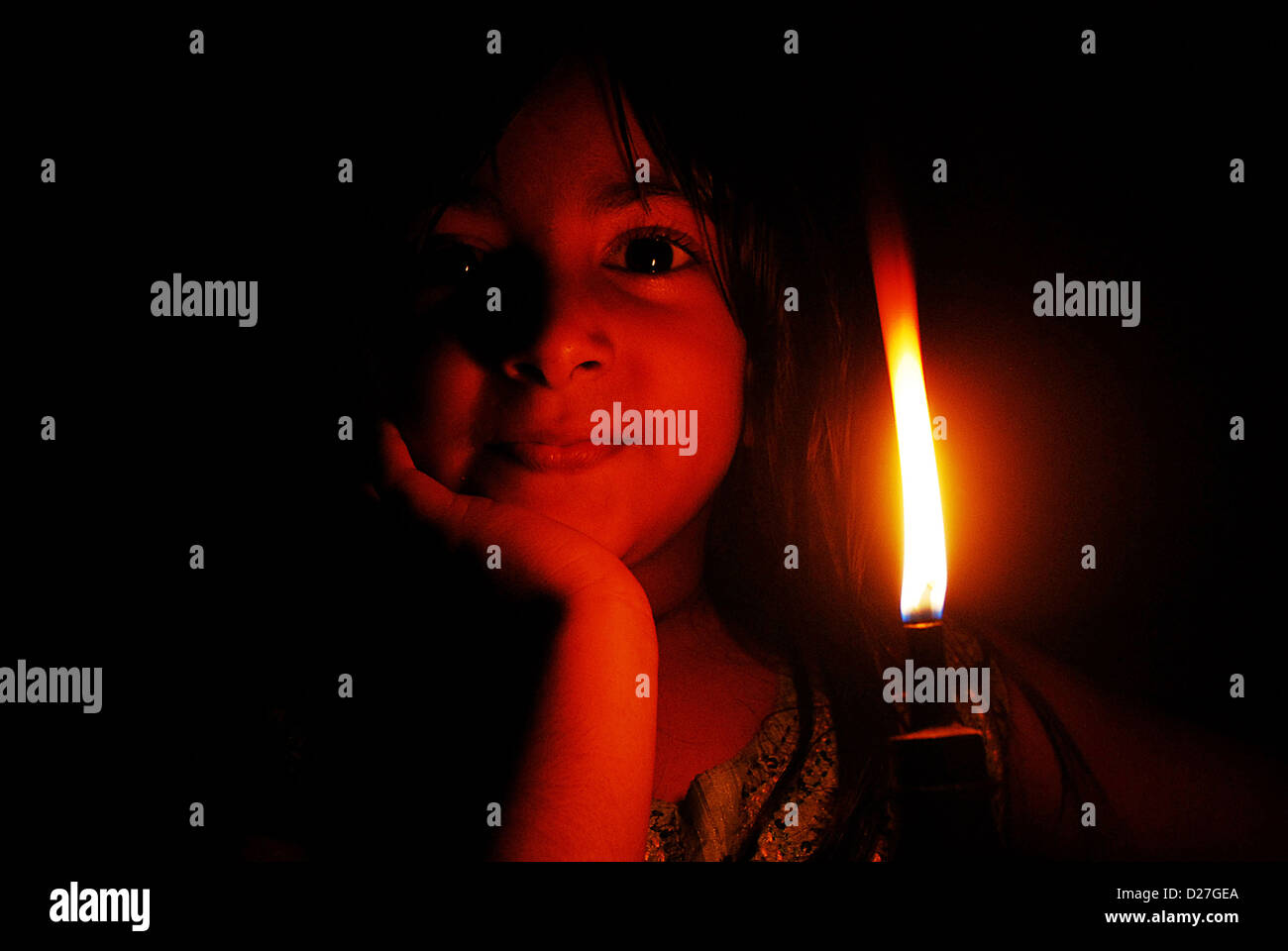 Una bambina al lume di candela Foto Stock