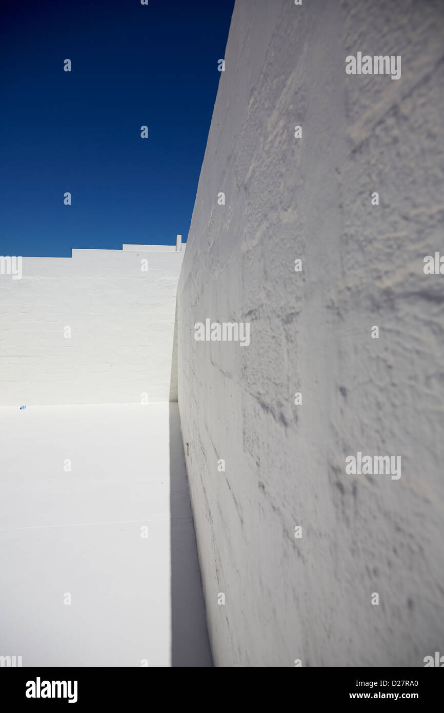 Abstract ampio angolo di un dipinto di bianco muro di pietra contro il cielo blu Foto Stock