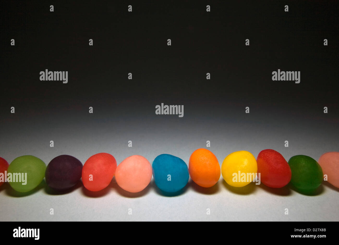 Jellybeans colorati in fila Foto Stock
