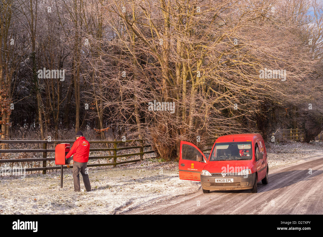 Southwold, Suffolk, Regno Unito. 16 gennaio 2013. Un Royal Mail portalettere fuori alla consegna si svuota una casella postale nella neve come le temperature nella zona raggiungere -10 gradi. Benacre , vicino a Southwold , Suffolk , Inghilterra , Inghilterra , REGNO UNITO Foto Stock