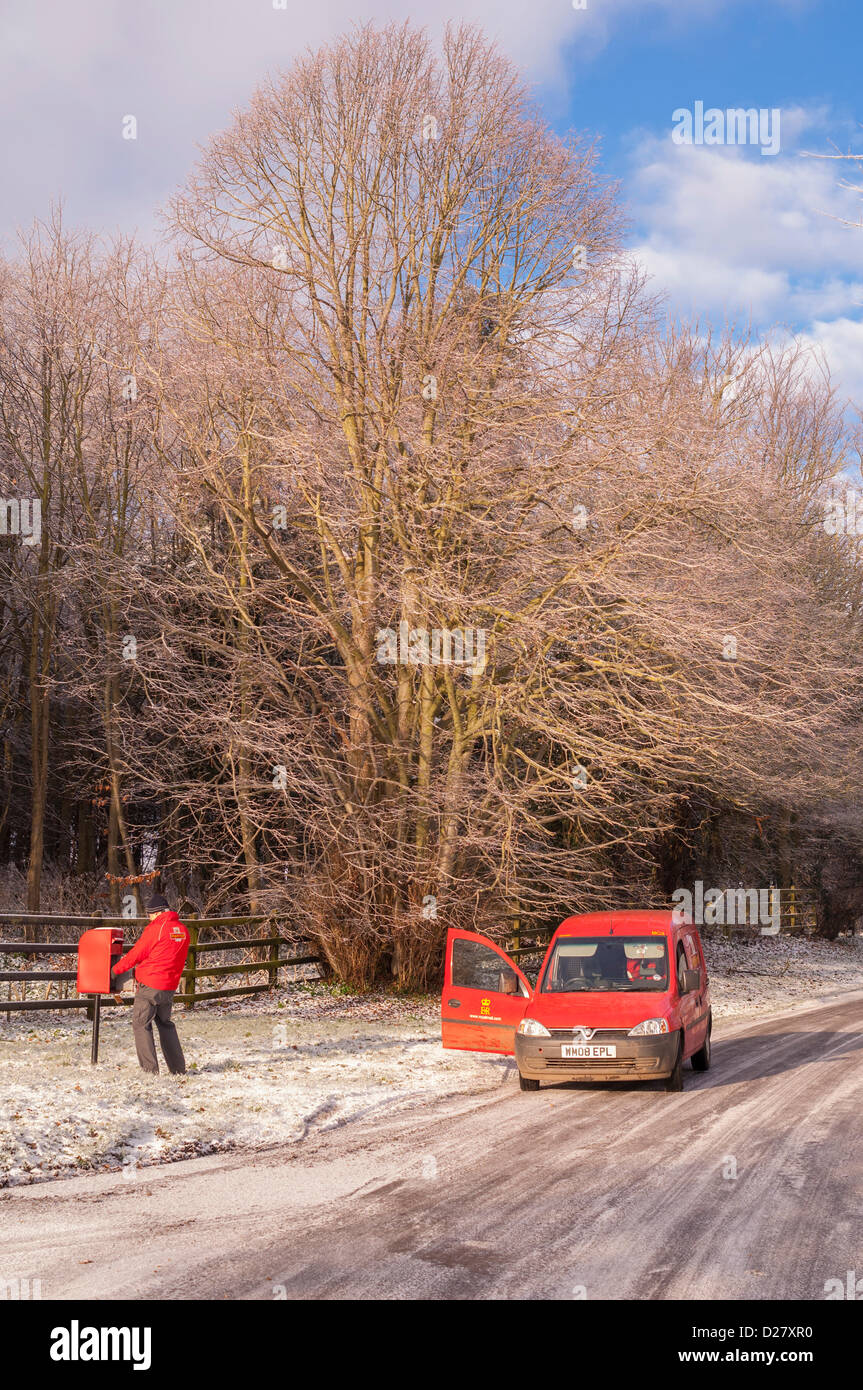 Southwold, Suffolk, Regno Unito. 16 gennaio 2013. Un Royal Mail portalettere fuori alla consegna si svuota una casella postale nella neve come le temperature nella zona raggiungere -10 gradi. Benacre , vicino a Southwold , Suffolk , Inghilterra , Inghilterra , REGNO UNITO Foto Stock