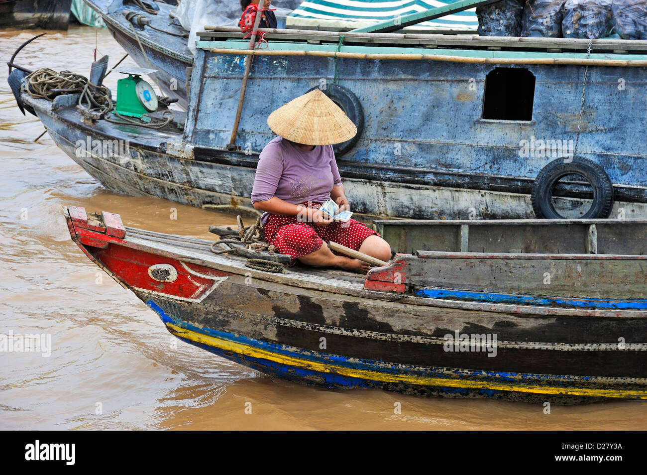 Il fiume Mekong, Vietnam, Tien Giang Provincia - donna su una barca di denaro di conteggio Foto Stock