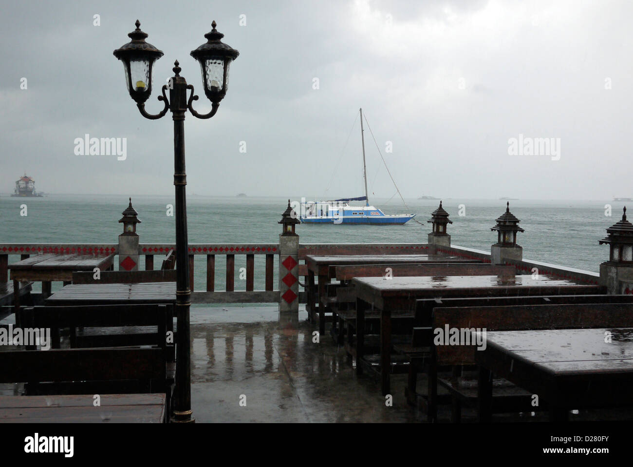 Heavy Rain in corrispondenza di una piscina esterna con bar e ristorante noto come 'beer garden' in Pattaya Thailandia Foto Stock