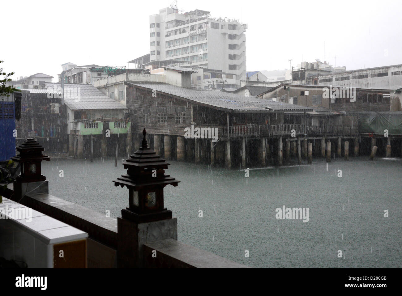 Costruzioni mare su palafitte in heavy rain fotografati da un bar all'aperto noto come 'beer garden' in Pattaya Thailandia Foto Stock