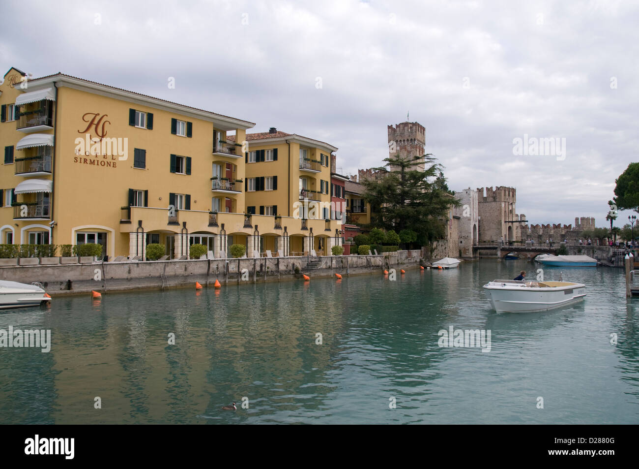 Una barca da diporto che porta turisti a Sirmione, sulla punta meridionale del Lago di Garda, in provincia di Brescia, nel nord Italia. In background è Foto Stock