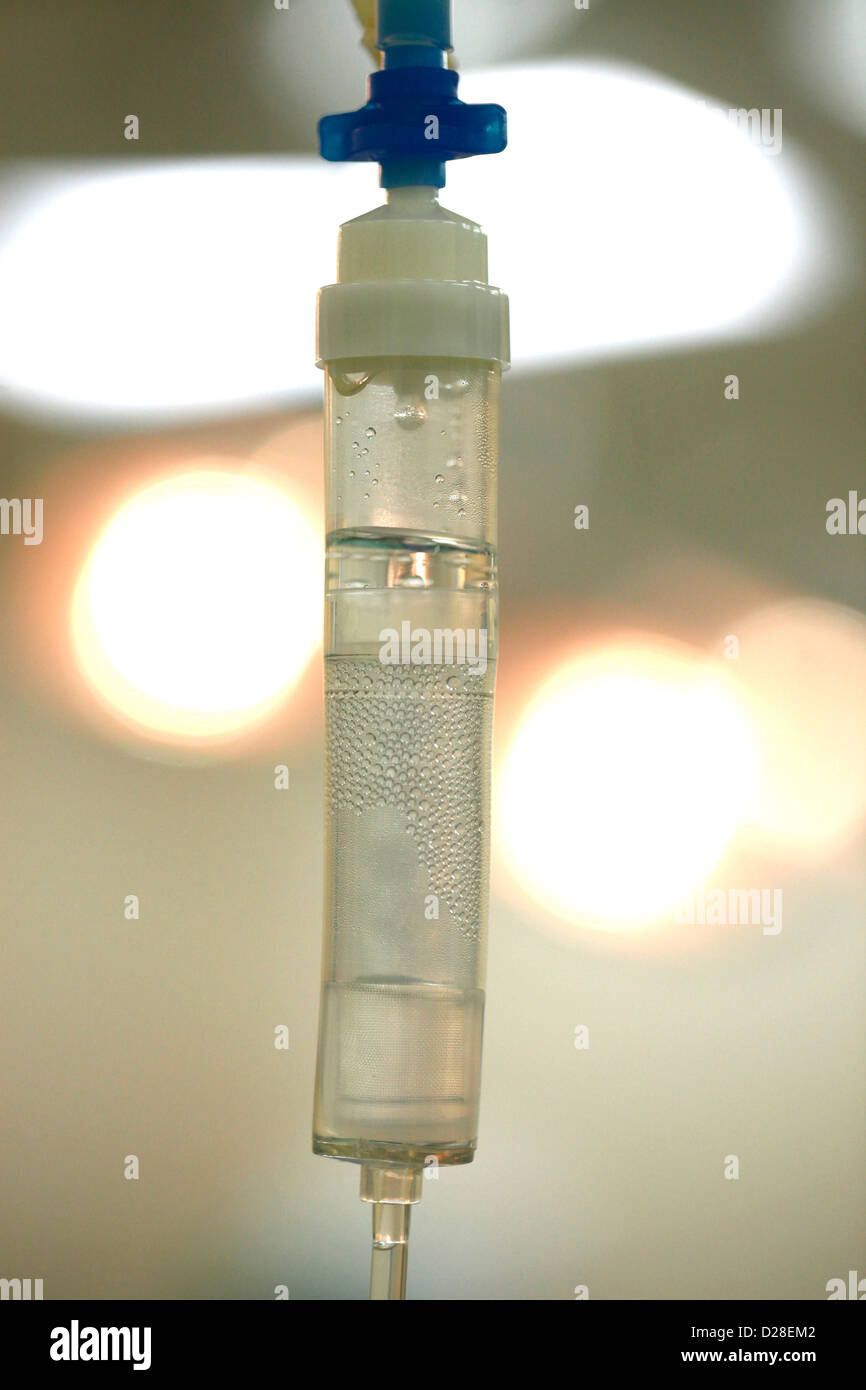 Un IV camera di gocciolamento collegato alla sacca di soluzione fisiologica Foto Stock
