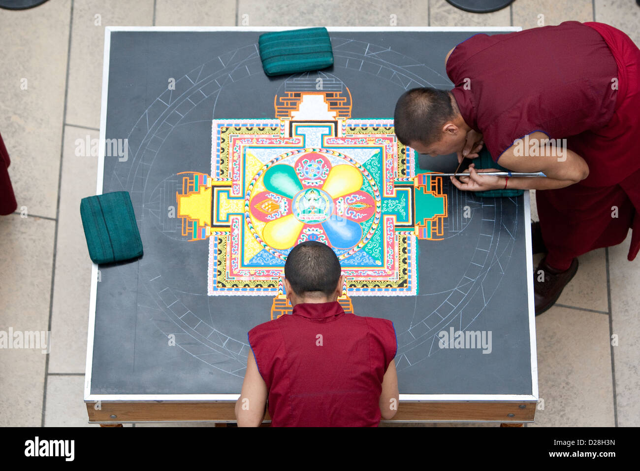 Monaci buddisti tibetani da Drepung Loseling Monastero, costruire un intricato, altamente modellato su larga scala mandala di sabbia Foto Stock
