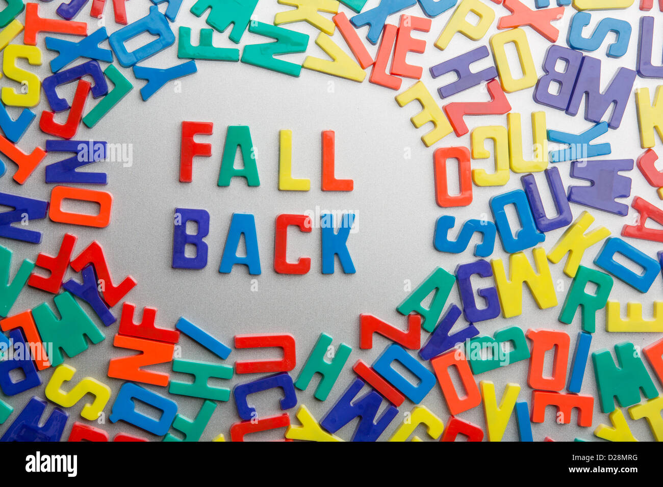 "Fall Back' - magneti da frigorifero scrivi un messaggio al di fuori di un'accozzaglia di lettere Foto Stock