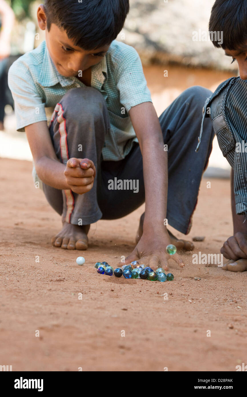 Ragazzi indiani la riproduzione di marmi in un territorio rurale villaggio indiano. Andhra Pradesh, India Foto Stock