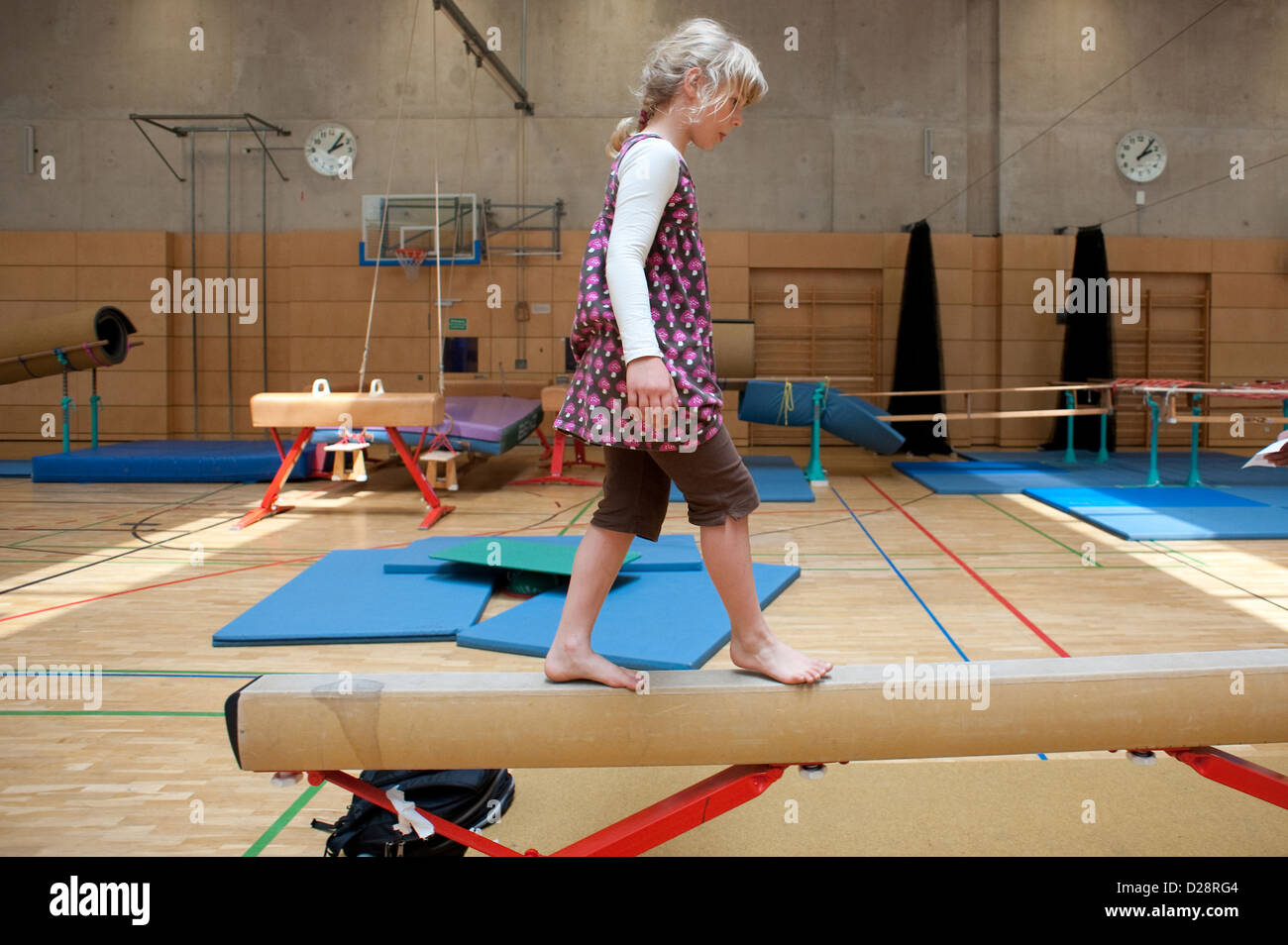 Berlino, Germania, ragazza bionda in equilibrio su una trave di equilibrio in una palestra Foto Stock