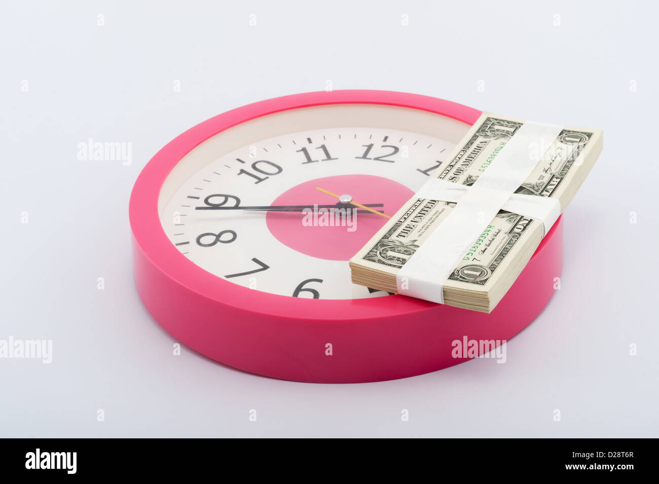 Orologio e una pila di carta moneta su sfondo bianco Foto Stock