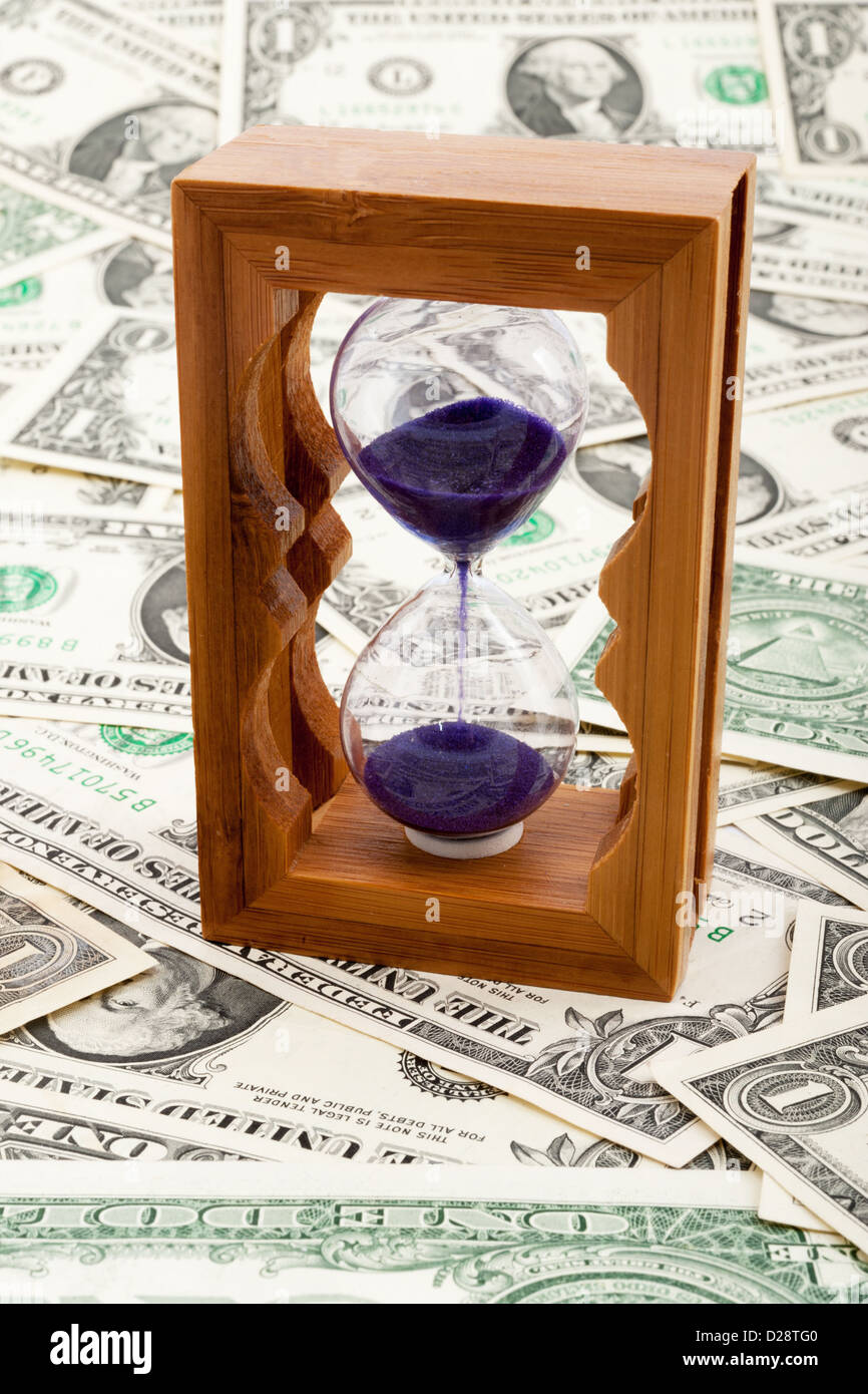 Clessidra su uno strato di carta moneta Foto Stock