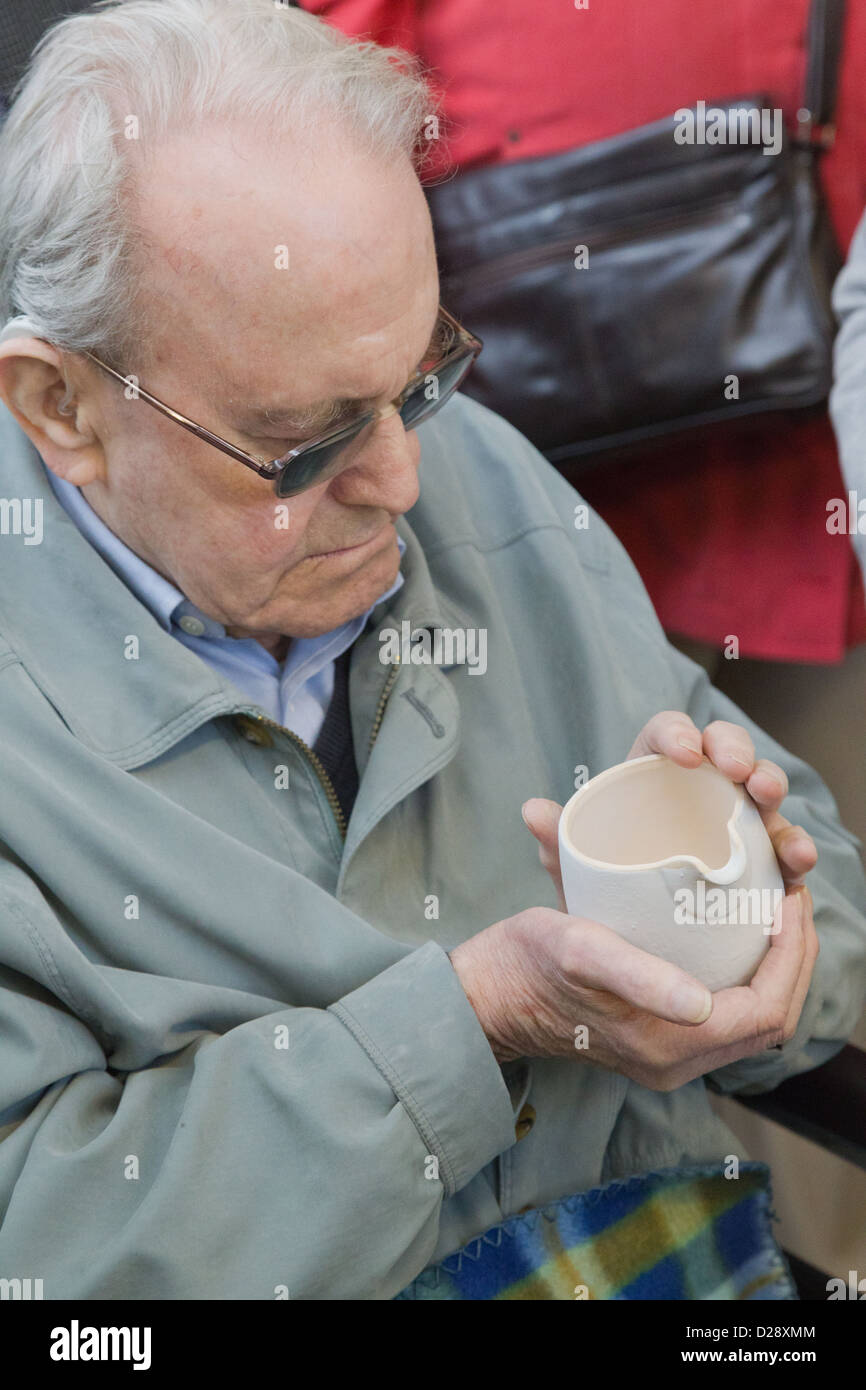 Da parte di persone ipovedenti e non vedenti con caregivers sulla gita a Denby Pottery. Toccare caraffa. Foto Stock