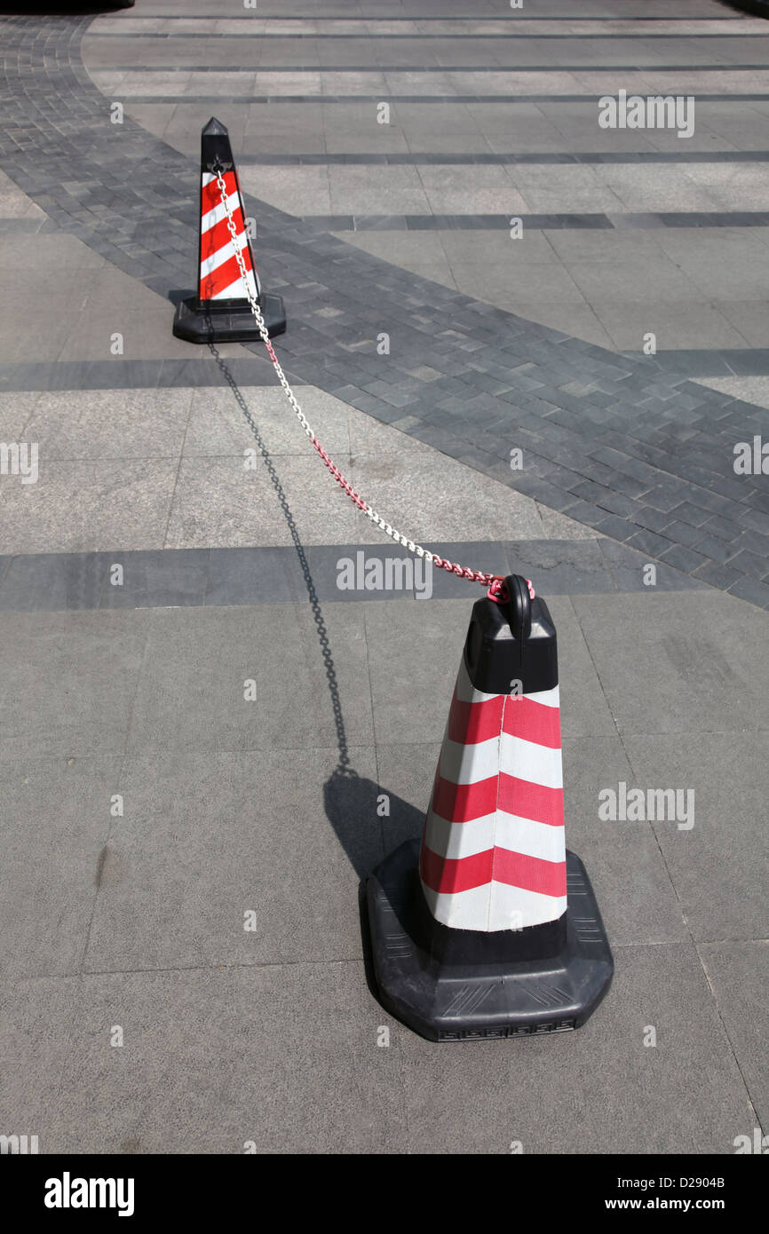 Si tratta di una foto di 2 coni o tenute link insieme con una catena di blocco per la strada o su strada per automobili Foto Stock