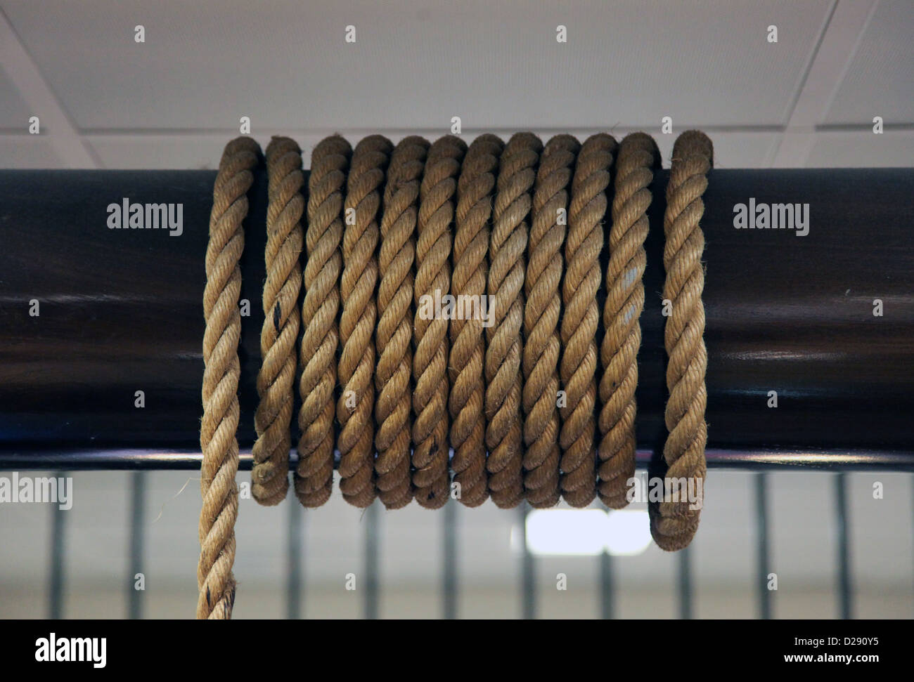 Si tratta di una foto di una lunga corda che viene arrotolato intorno a un bastone di legno in una barca sul mare Foto Stock