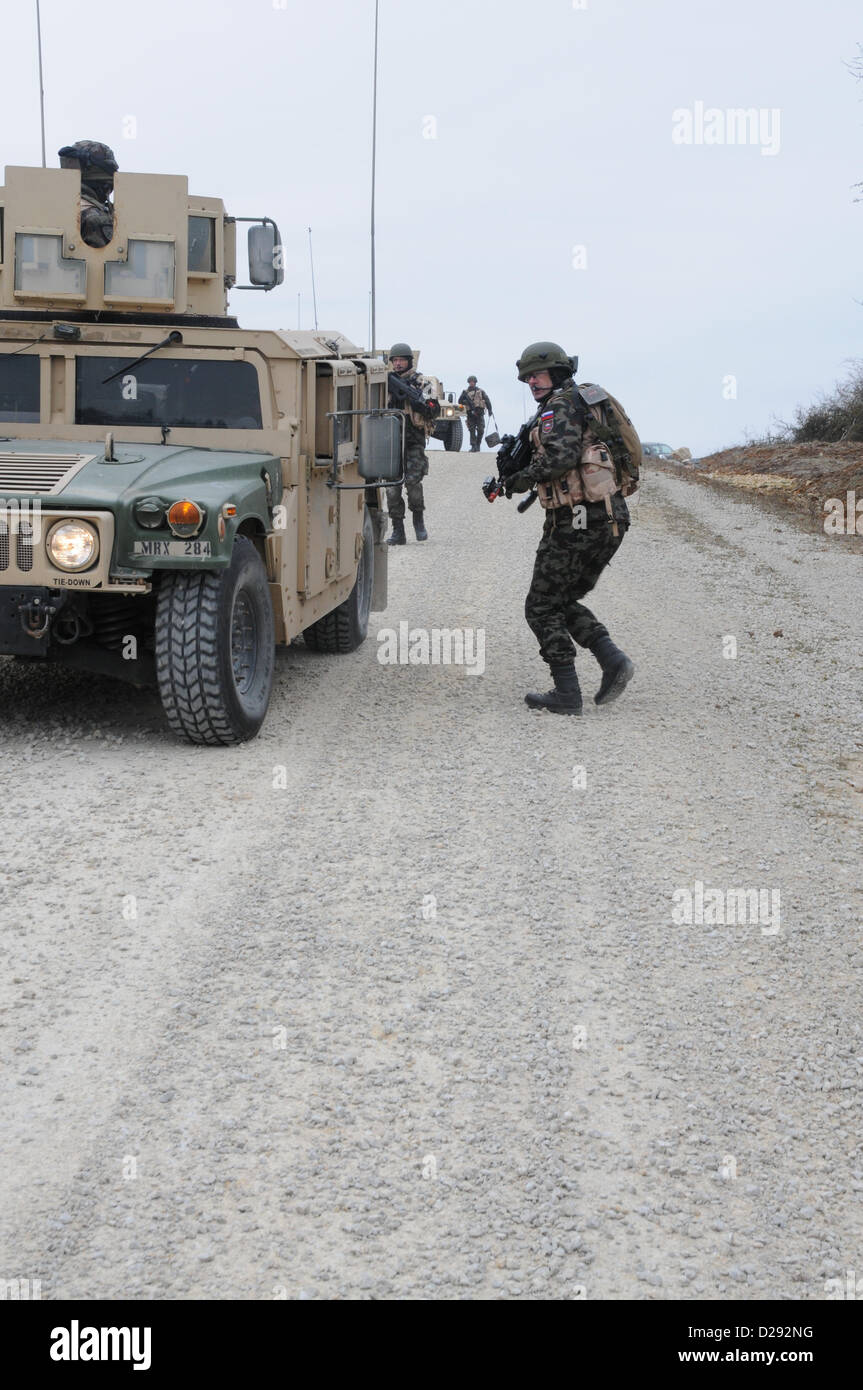 Hohenfels, Germania, 17 gennaio 2013. Un esercito sloveno soldato del 1° Brigata motorizzata tira la sicurezza accanto a un Humvee durante un militare di advisory team (MAT) esercizio presso la multinazionale comune disponibilità centro in Hohenfels, Germania, 17 Gennaio 2013tappetini e di polizia ai team di consulenza sono progettati per replicare l'Afghanistan ambiente operativo durante la preparazione di squadre per operazioni di counterinsurgency con la capacità di formare, consigliare e abilitare l'Afghanistan esercito nazionale e l'Afghanistan della polizia nazionale. (U.S. Esercito foto di Sgt. Gemma Iglesias/rilasciato) Foto Stock