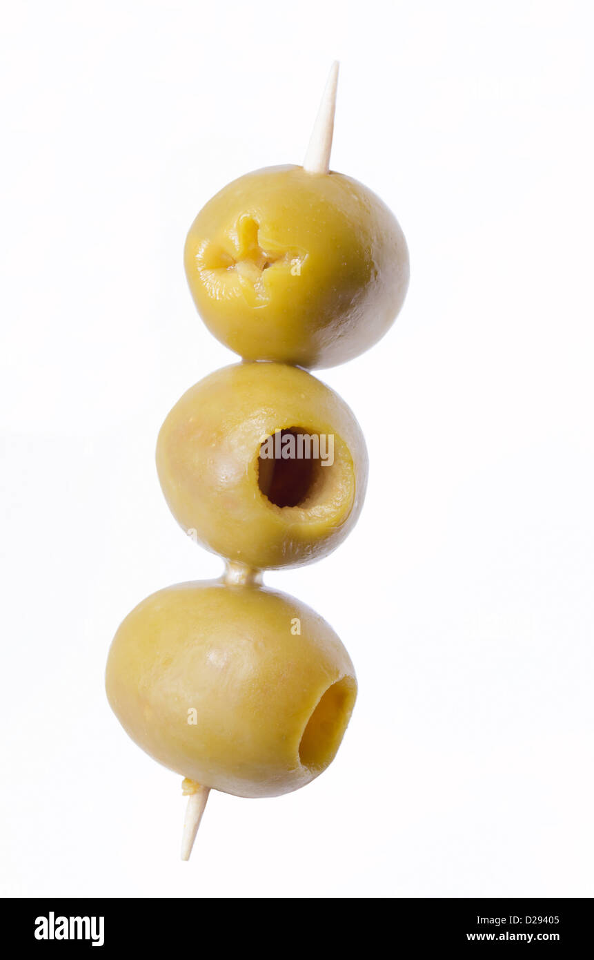 Tre olive verdi snocciolate sul bastone di legno Foto Stock
