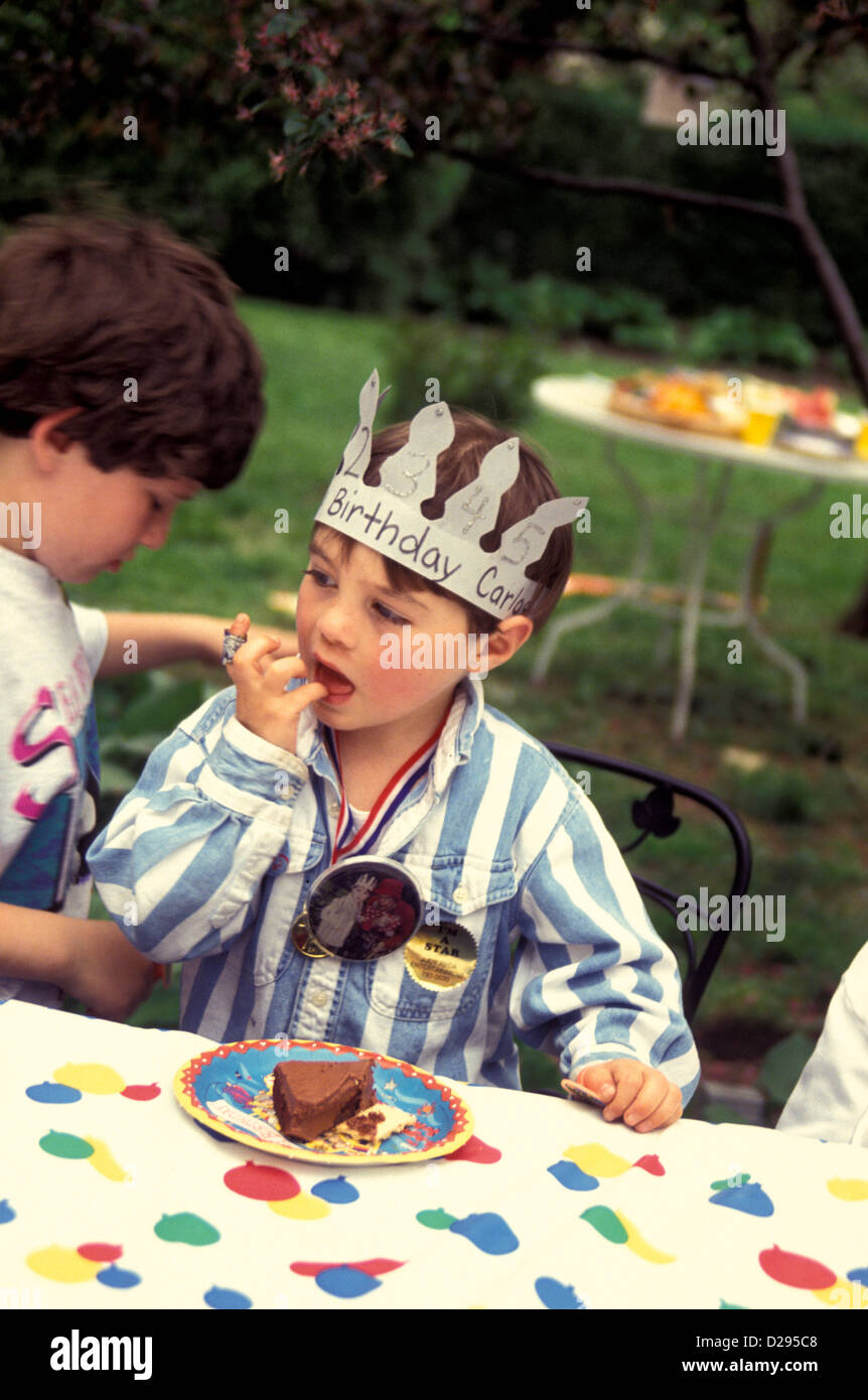 Cinque anni di vecchio ragazzo di mangiare la sua torta di compleanno Foto Stock