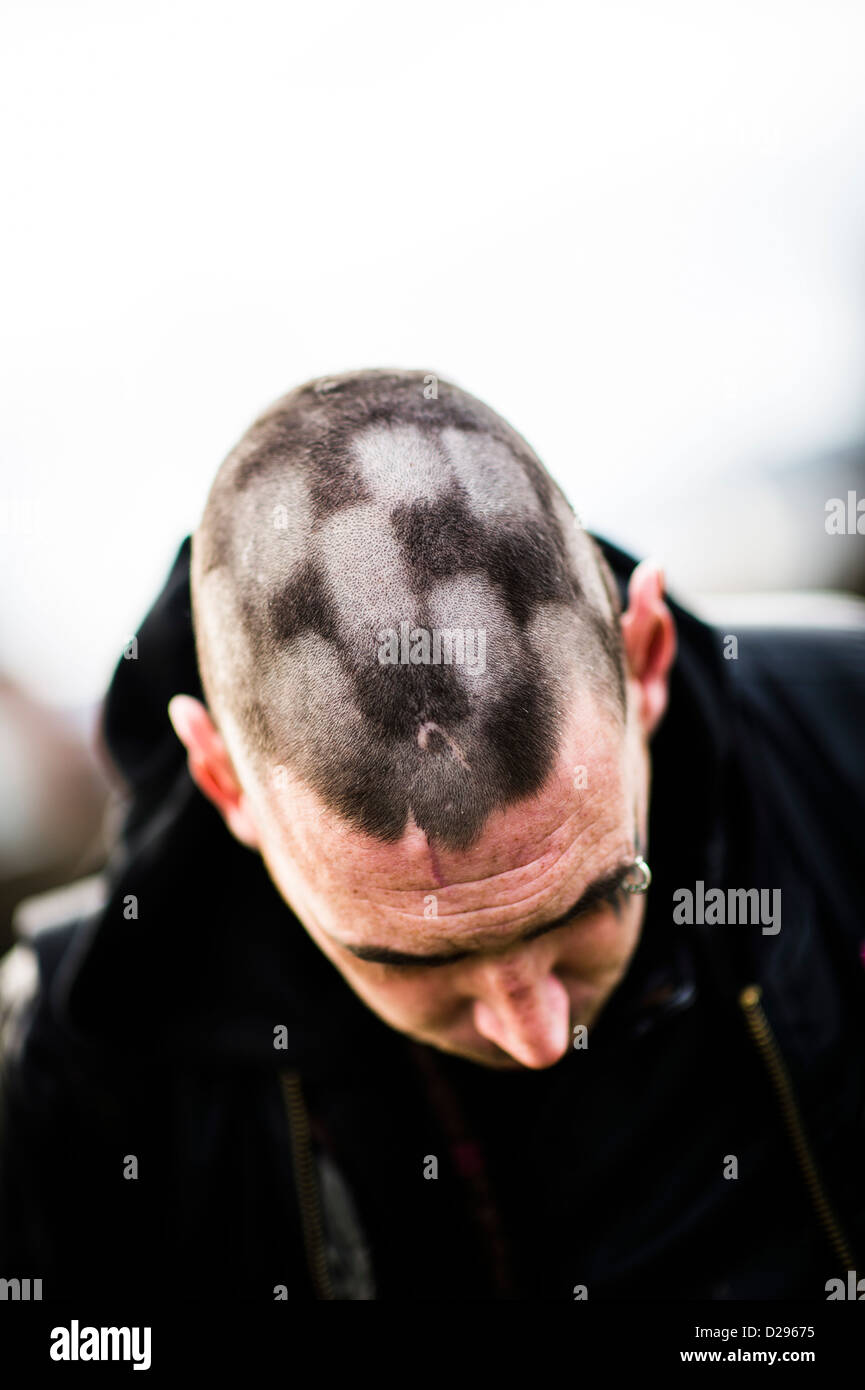 Un punk uomo con i capelli sulla sua testa rasata in un a scacchi scacchi scacchi-board piazze pattern, REGNO UNITO Foto Stock