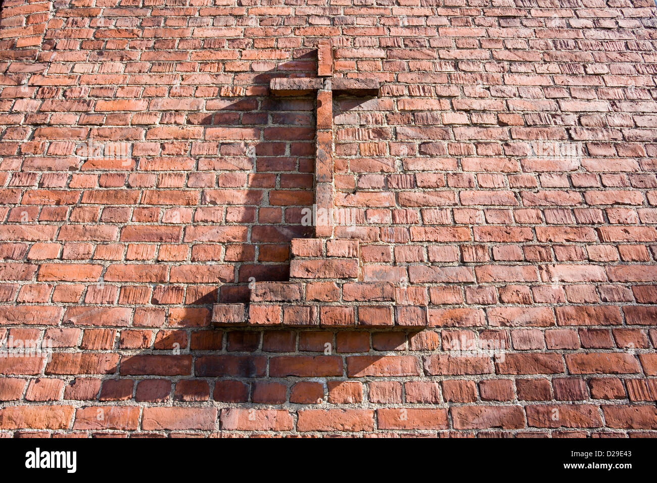 Christian croce di colore rosso sul muro di mattoni Foto Stock