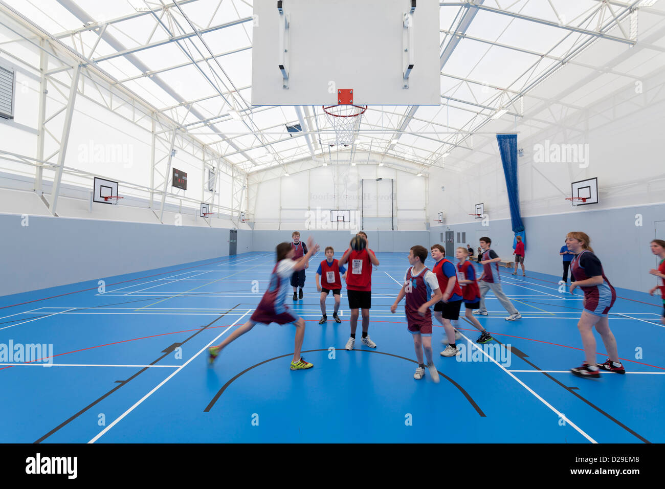 Bambini palying basketball interno school sports hall Foto Stock