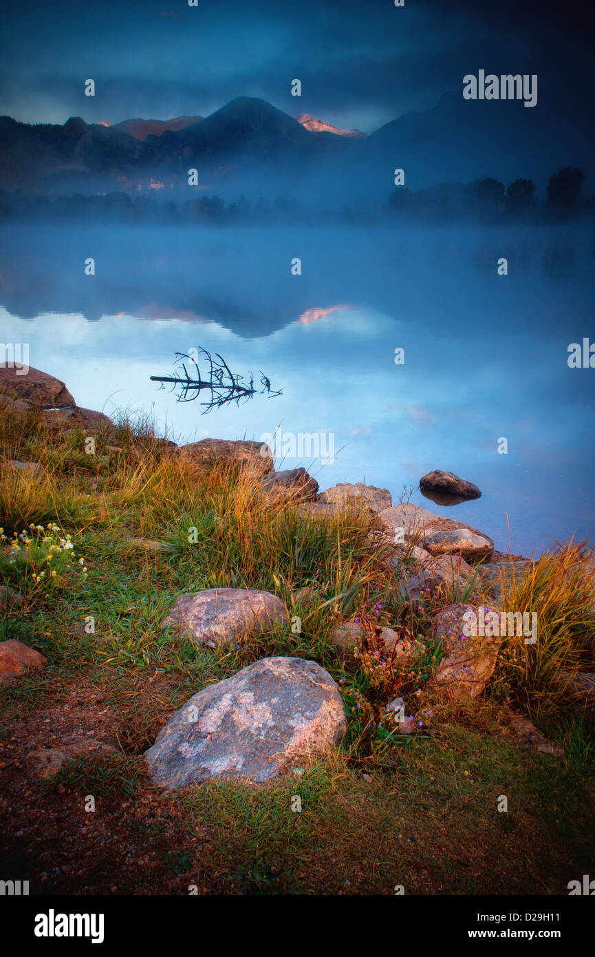 La nebbia comincia a rotolare in oltre il Lago Estes creando una drammatica scena all alba di una splendida mattina autunnale in Estes Park, COLORADO Foto Stock