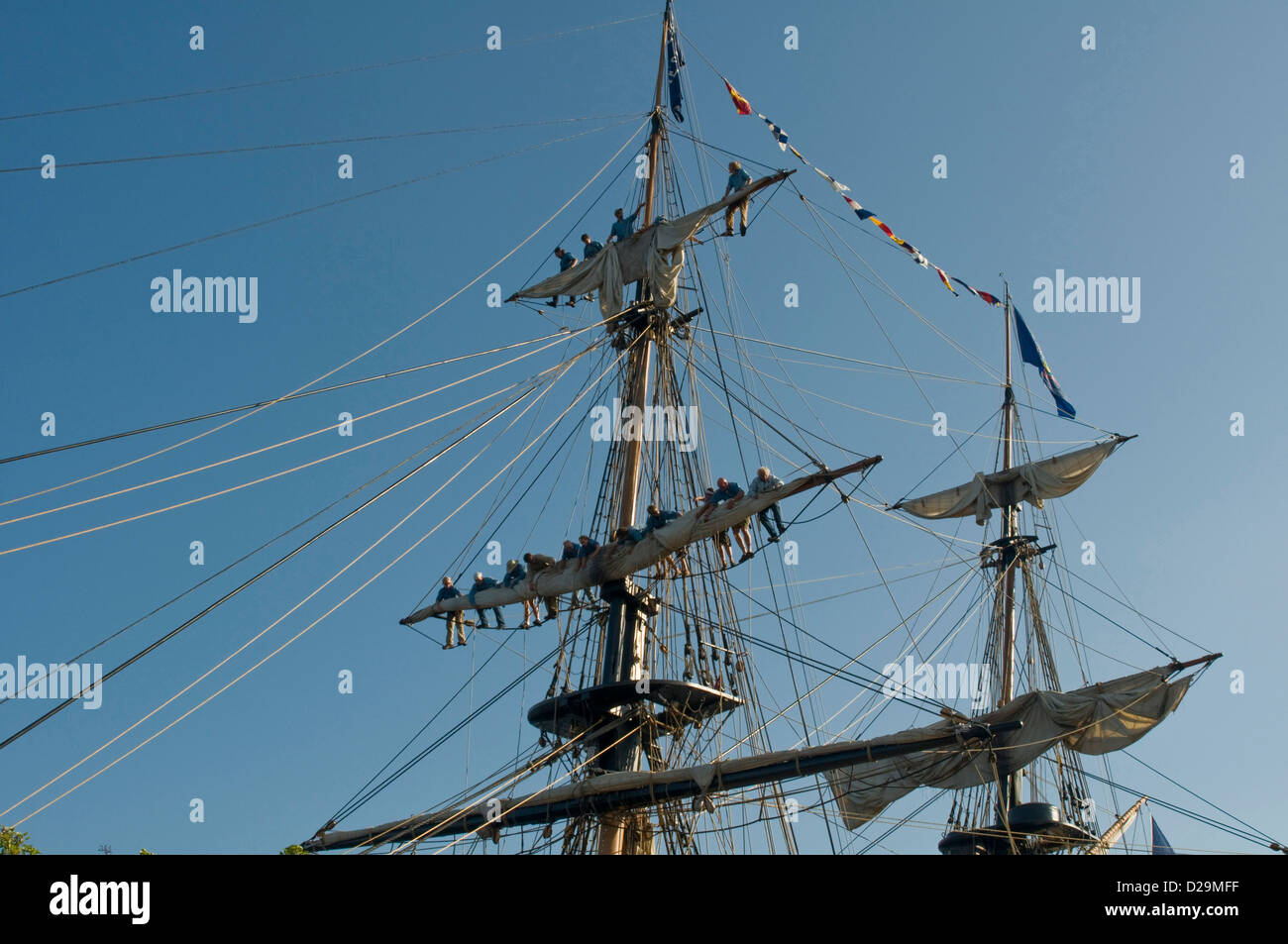 Tall Ship equipaggio la piegatura delle vele Foto Stock