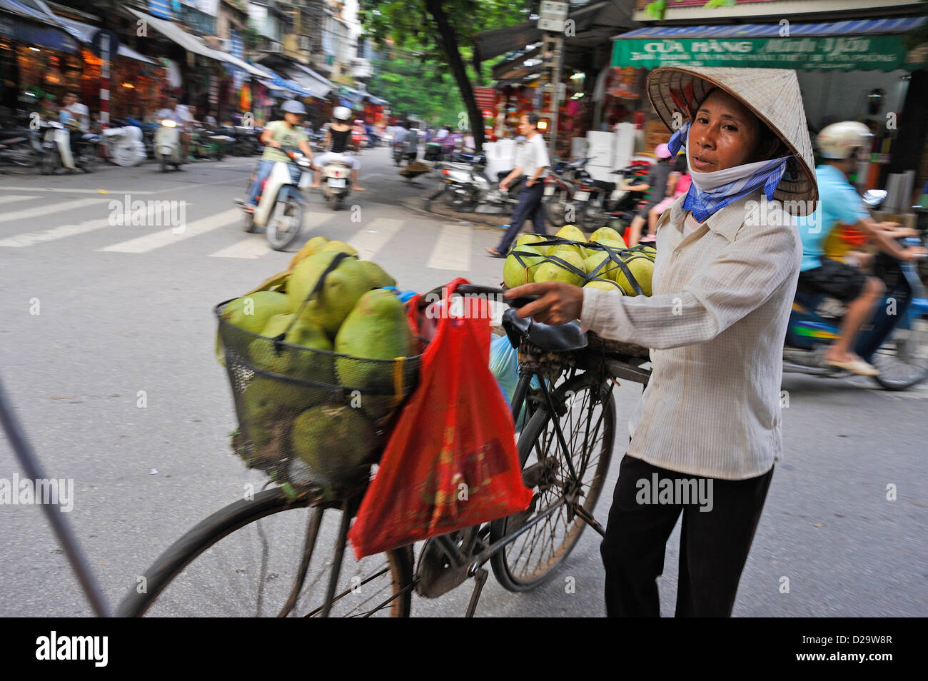 Hanoi, Vietnam - Donna vendita / trasporto di frutta - persone in Vietnam street scene Foto Stock
