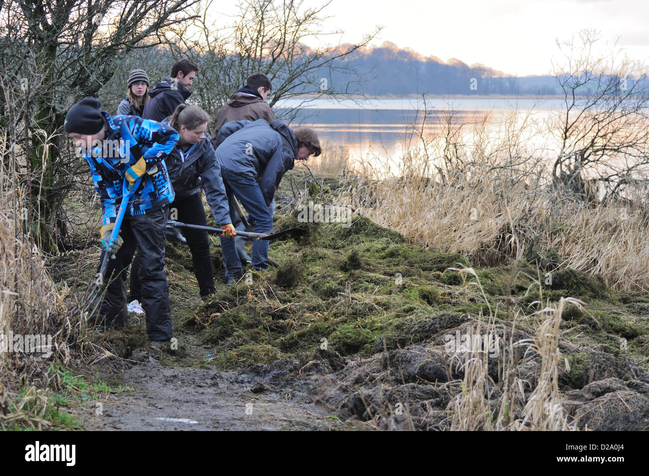 Gli adolescenti la cancellazione di un percorso dopo le alluvioni Muirshiel country park presso il castello semple, Lochwinnoch, Scozia Foto Stock