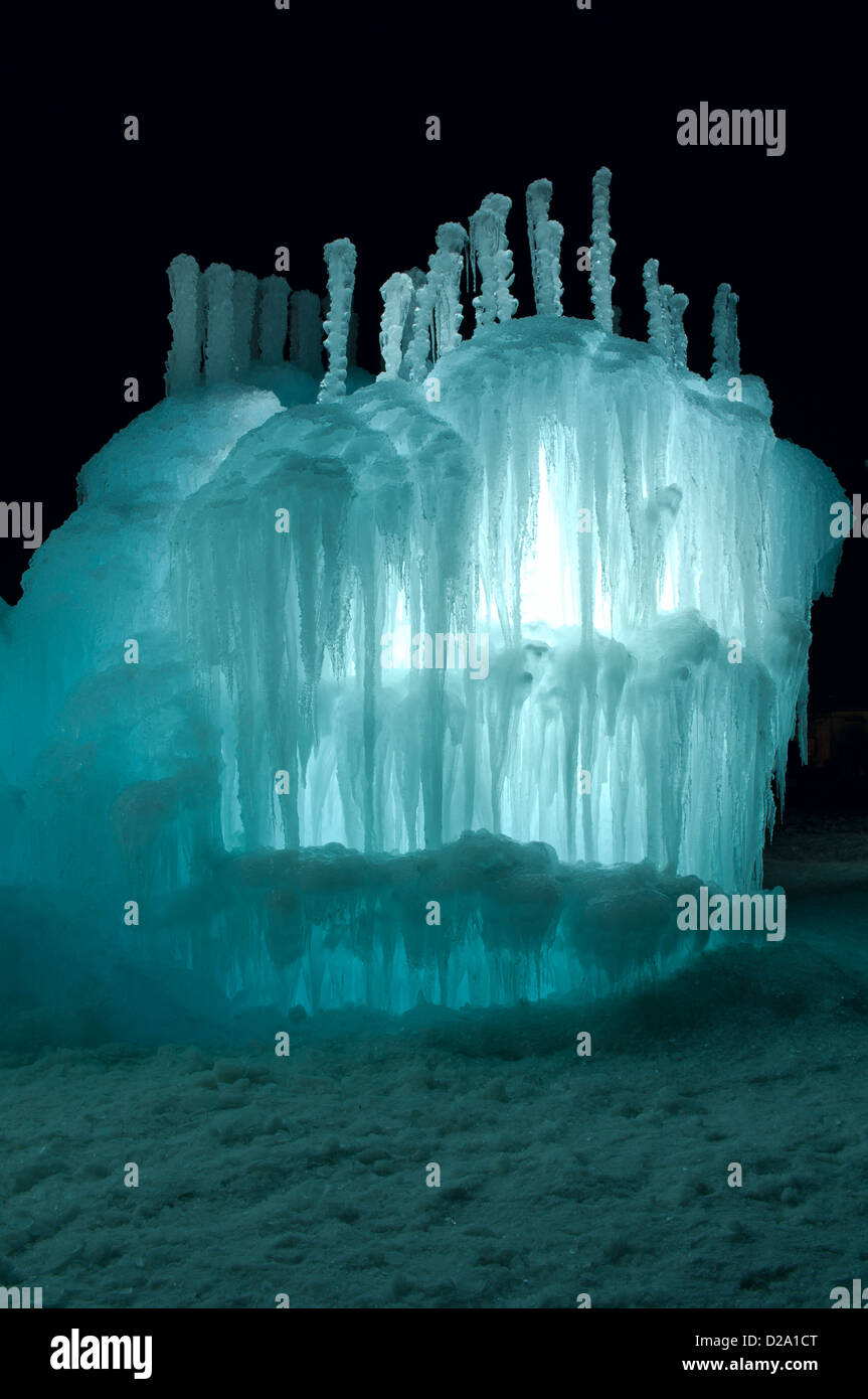 Torre di ghiaccio e la scultura illuminato con acquamarina LED colorati e decorati con ghiaccioli di notte Foto Stock