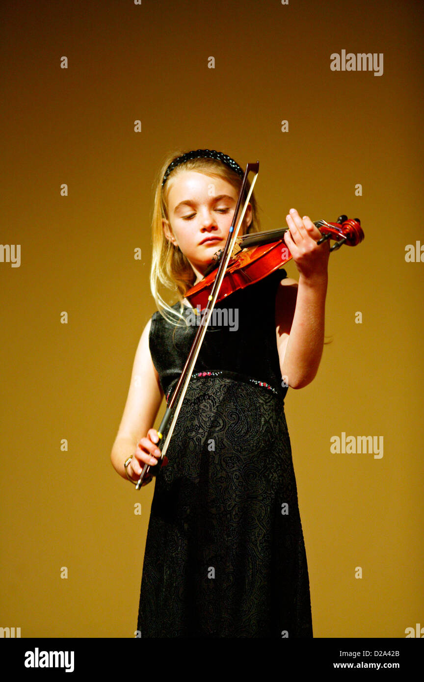 Ragazza effettuando in corrispondenza di un violino considerando. Foto Stock