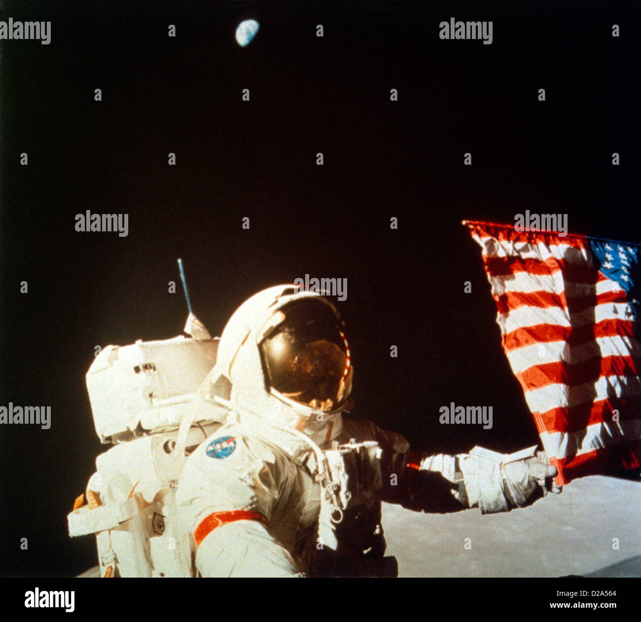 Astronauta Eugene Cernan, Apollo 17 sulla luna con U.S. Bandiera, terra visibili. Foto Stock
