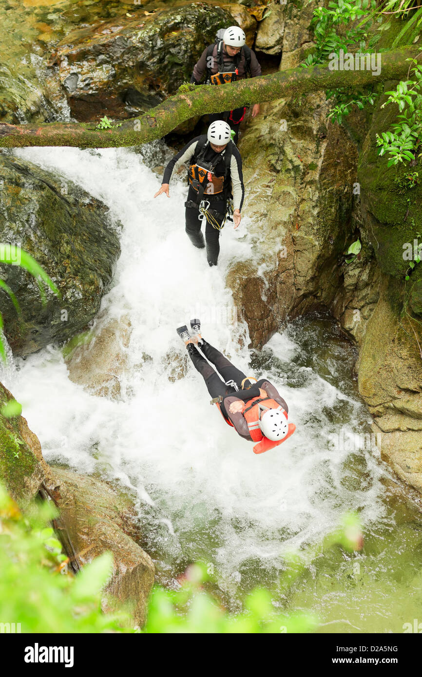 Canyoning Team di eseguire un backflip in una piccola cascata Foto Stock