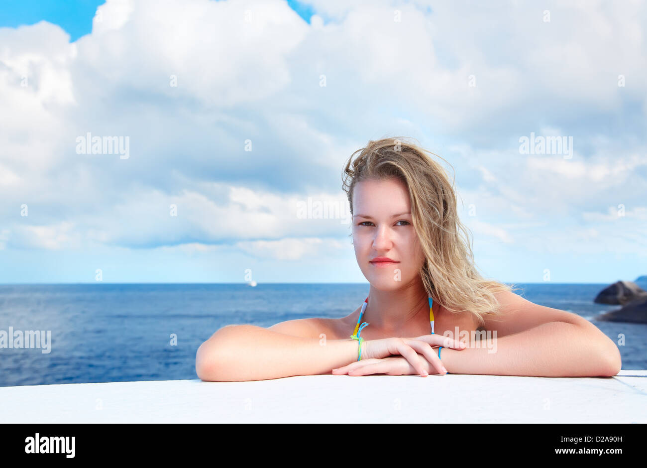 Outdoor Ritratto di giovane e bella donna bionda all'esterno. azzurro mare e cielo nuvoloso sullo sfondo Foto Stock