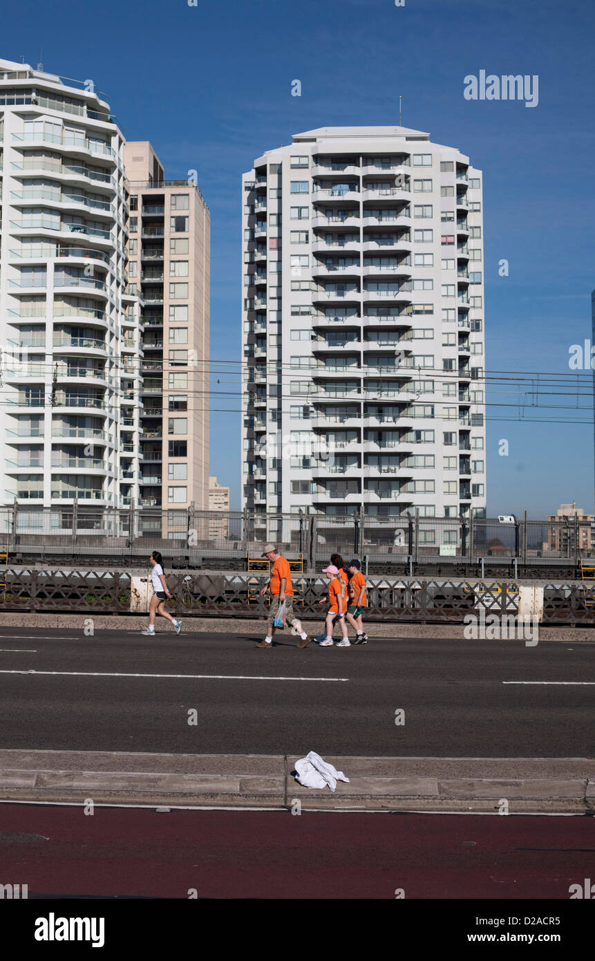 Piccolo gruppo di persone che fanno la loro strada attraverso un deserto il Ponte del Porto di Sydney che era chiuso per una carità fun run Foto Stock