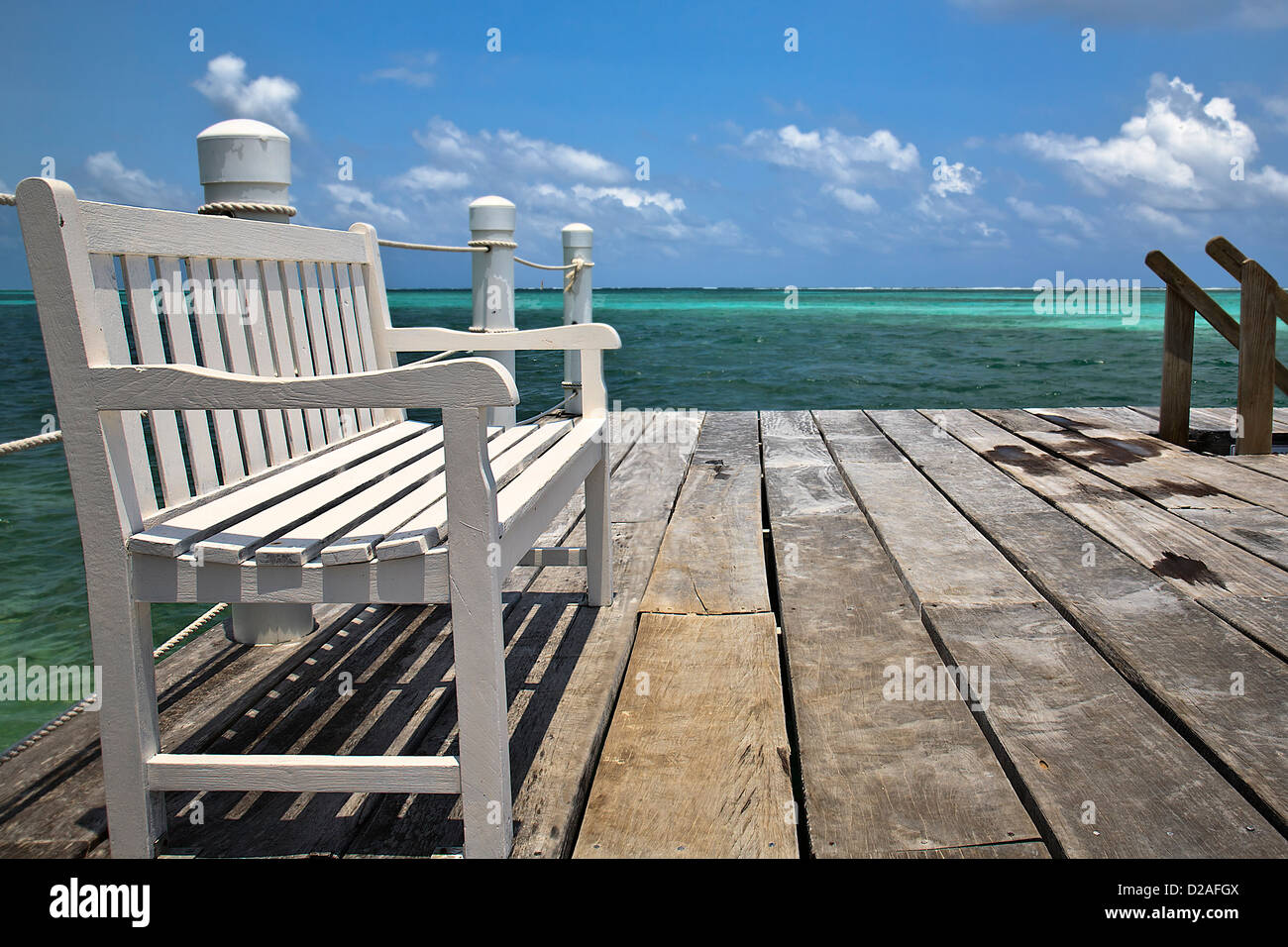 Un banco si trova vuota con vista dell'oceano turchese, nell'isola di San Pedro in Belize Foto Stock
