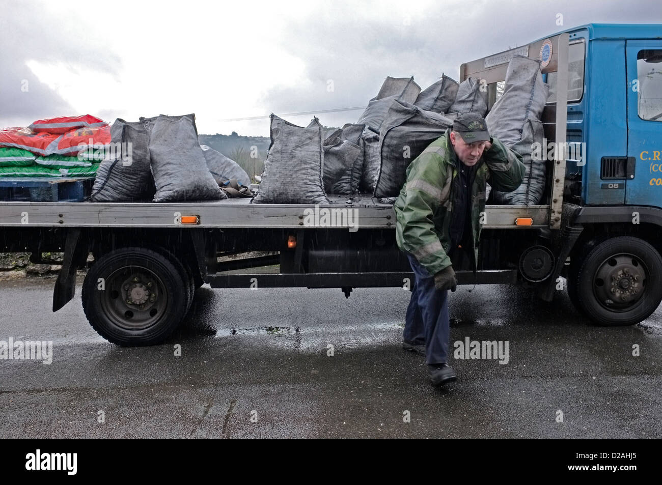 L'uomo offrendo i sacchi di carbone, Cornwall, Regno Unito Foto Stock