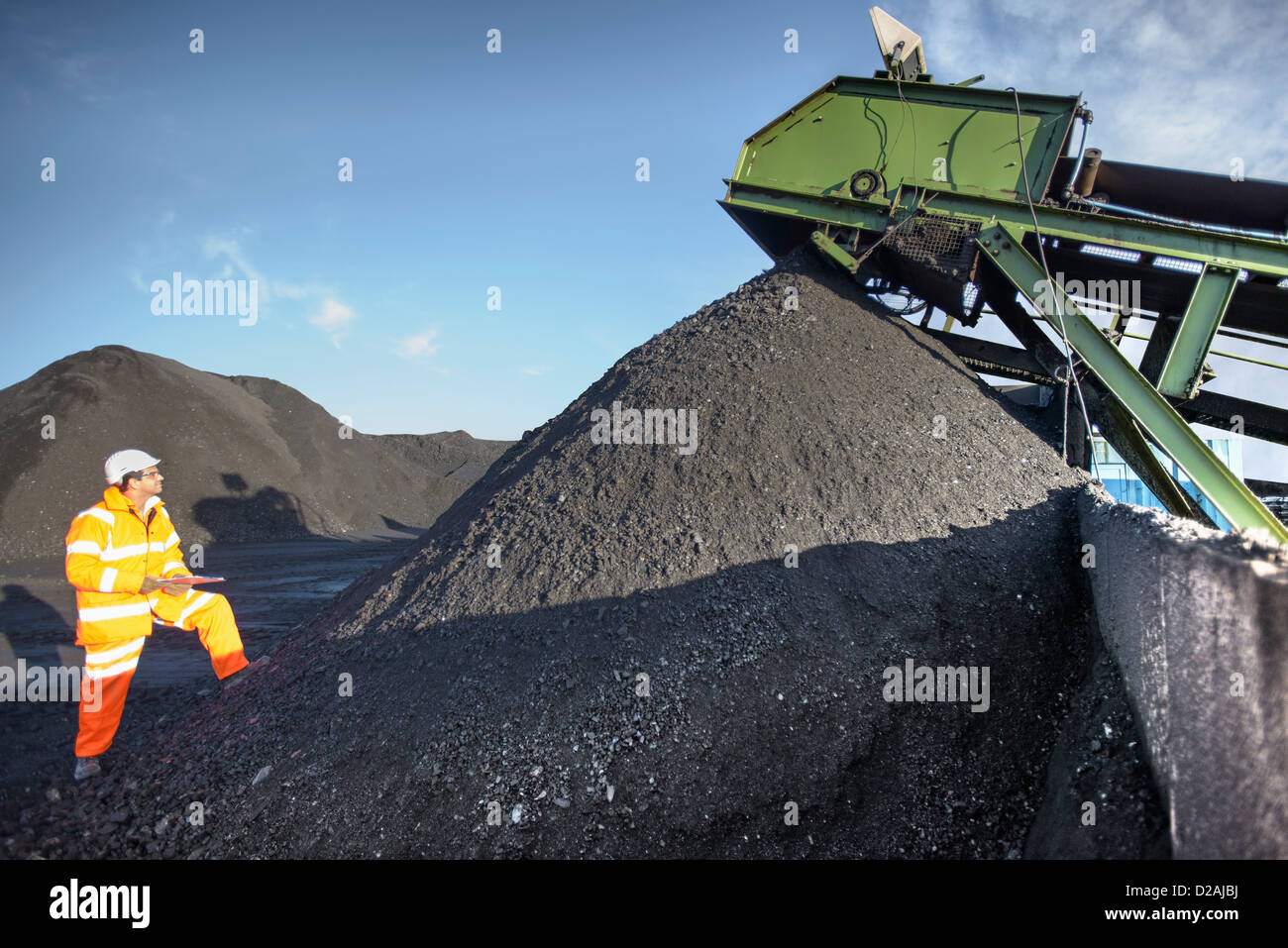 Lavoratore esaminando mucchio di carbone in miniera Foto Stock